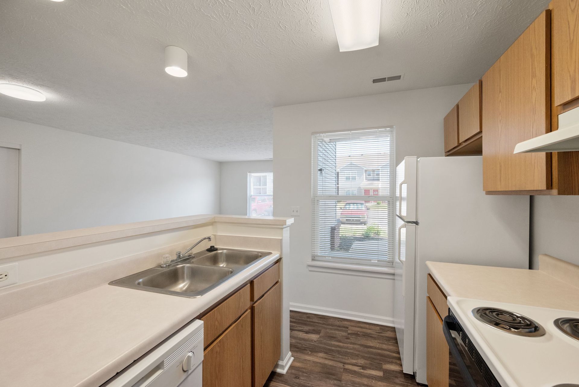 A kitchen with a sink , stove , refrigerator and dishwasher.