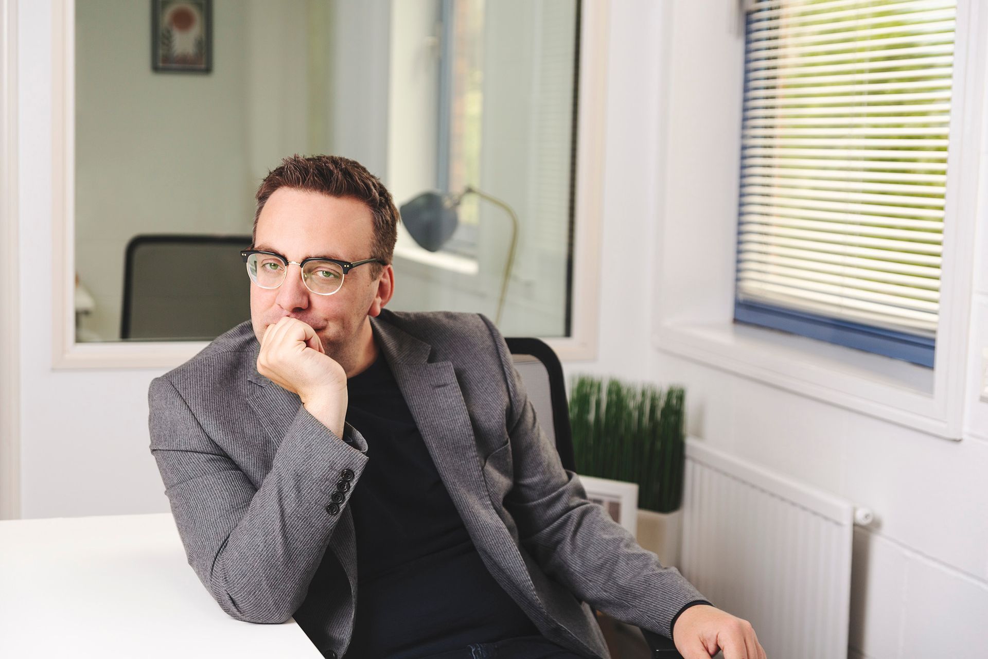 Portrait of a smart professional man sitting at an office desk looking towards camera - shot by Dammo Photography
