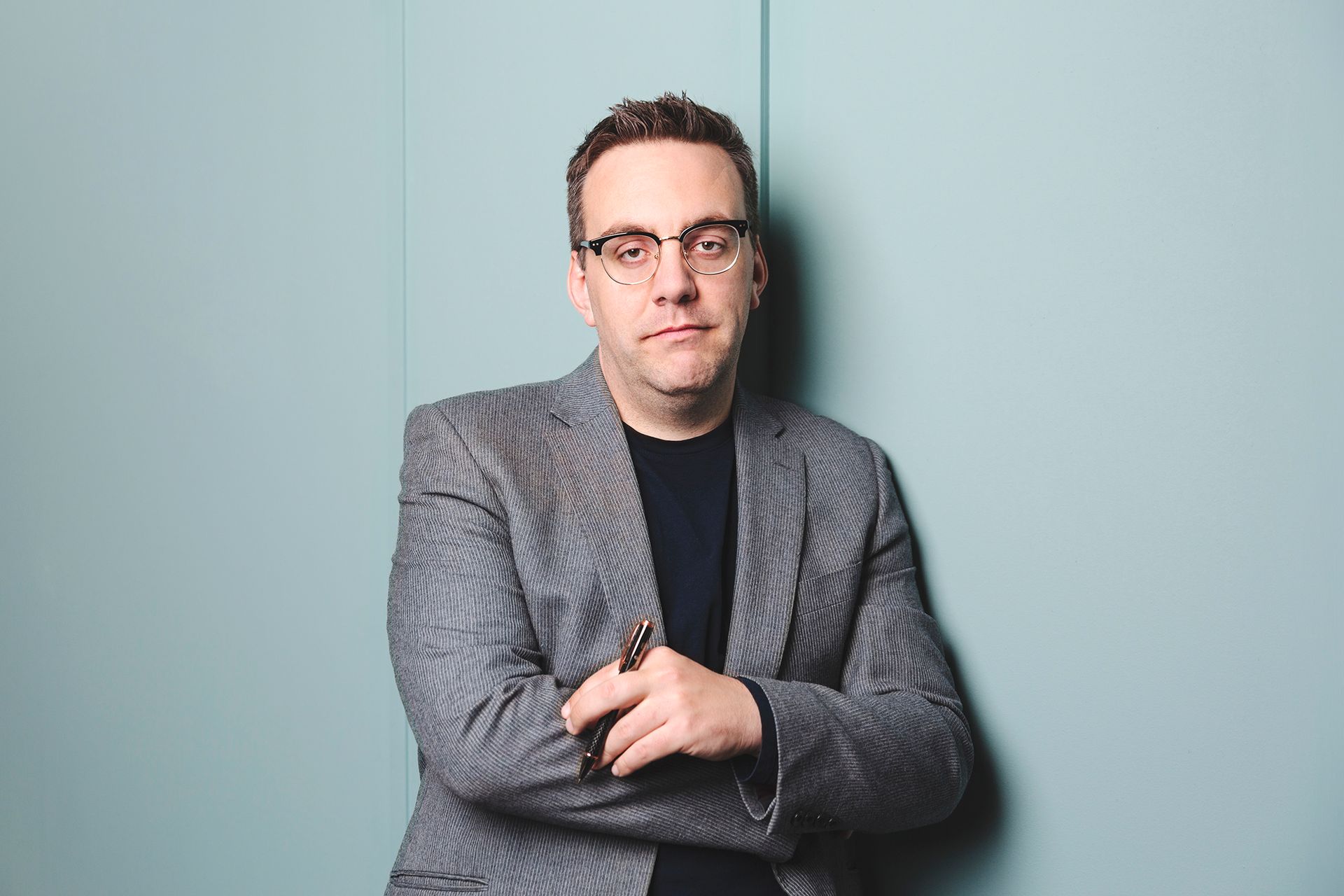 Portrait of a smart professional man leaning against a wall shot by Dammo Photography