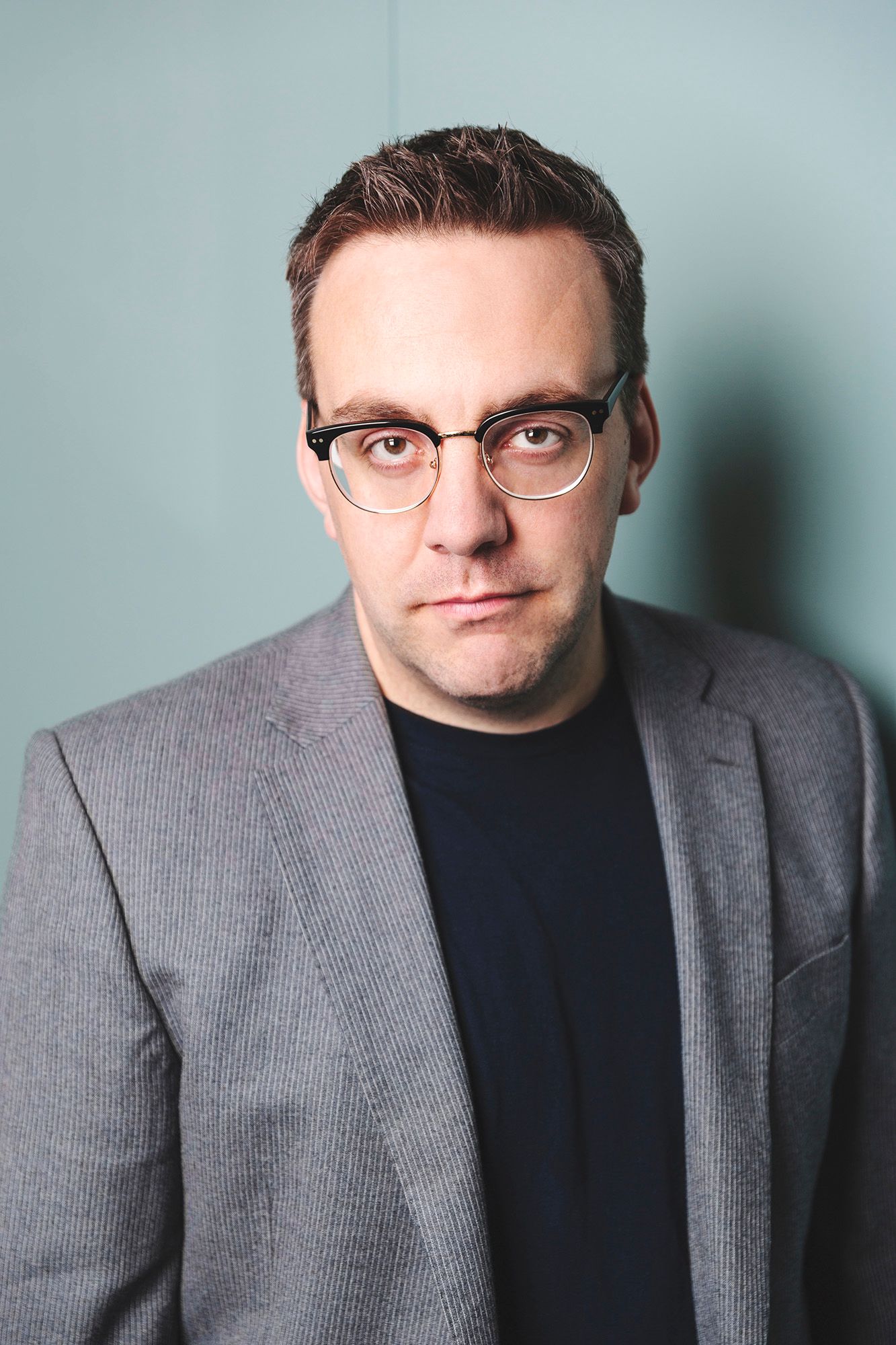 Portrait of a smart professional man leaning against a wall shot by Dammo Photography