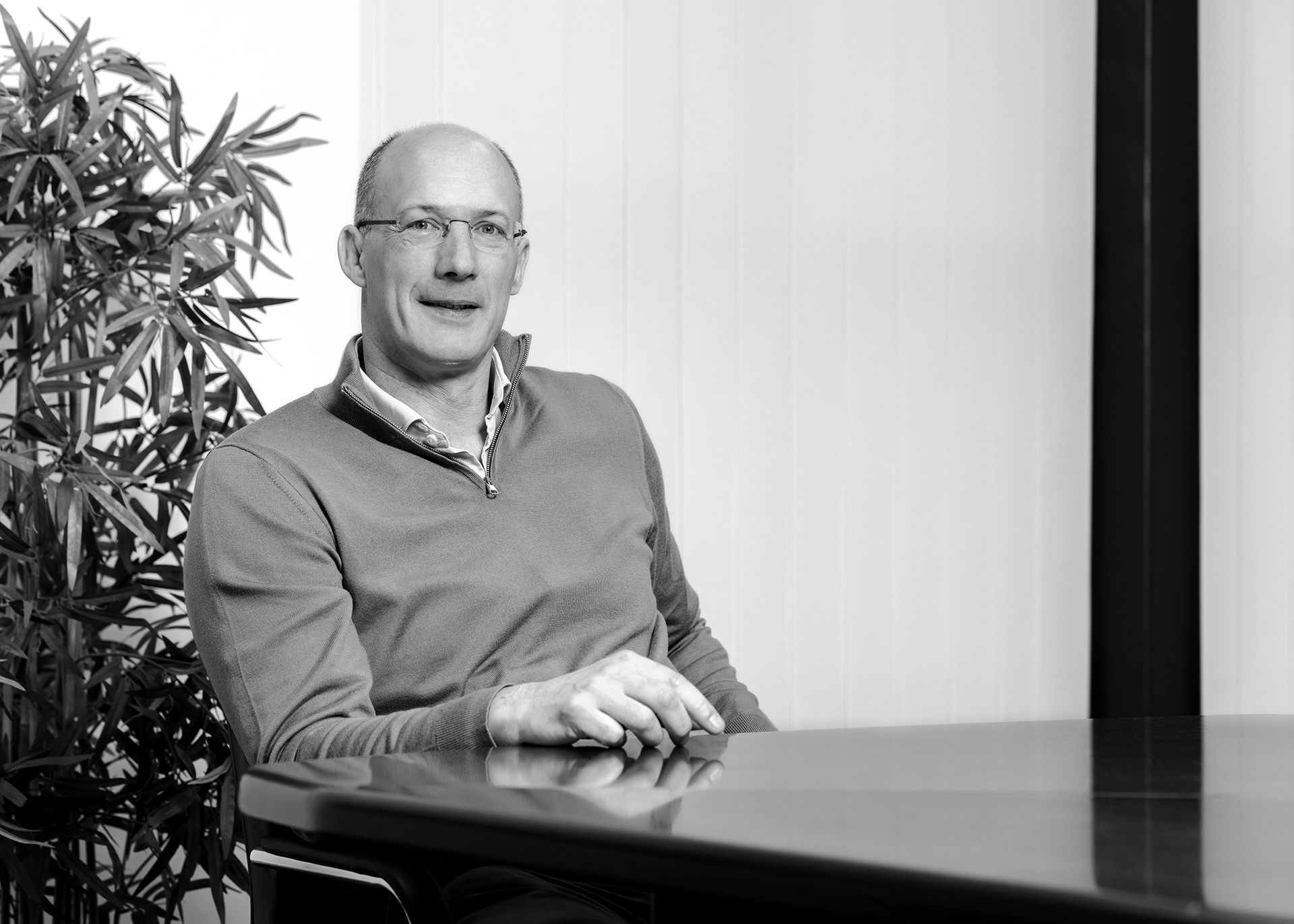 Black and white Portrait of a smart professional man sat at a boardroom table shot by Dammo Photography
