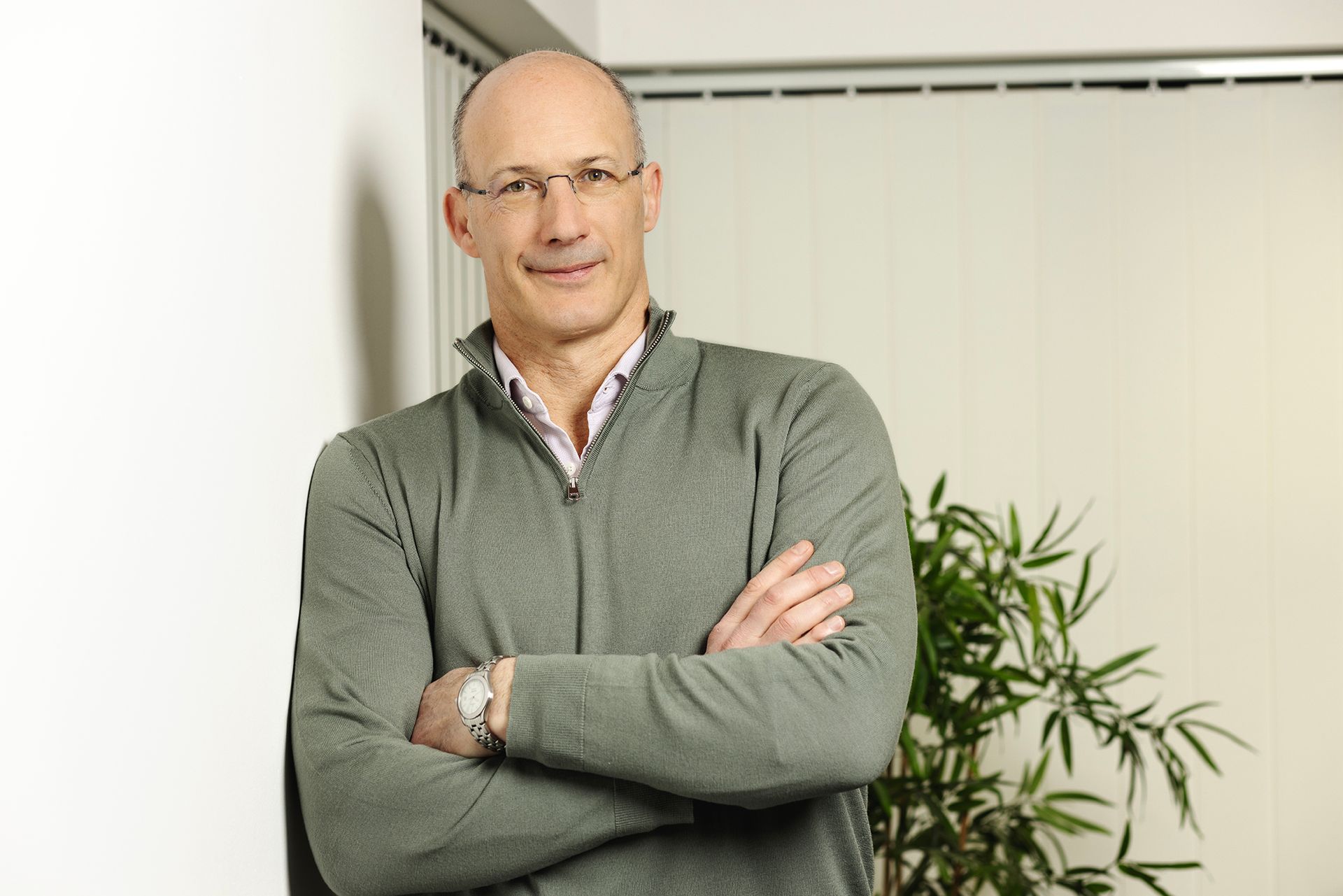 Portrait of a smart professional man leaning against a wall shot by Dammo Photography