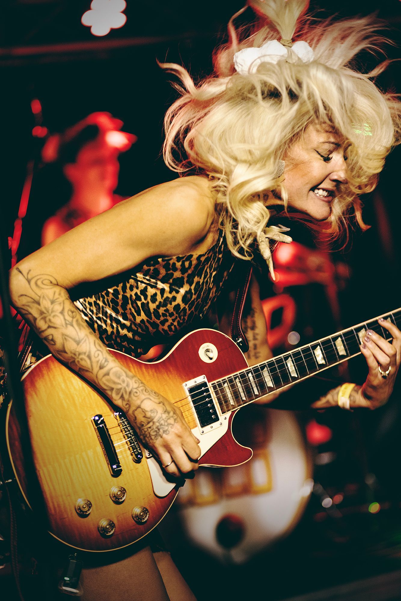 A woman in a leopard print dress is playing a guitar shot by Dammo Photography