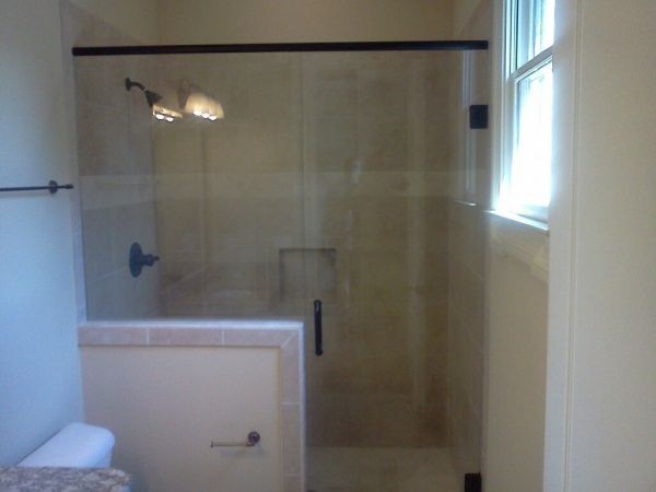 A bathroom with a sliding glass shower door