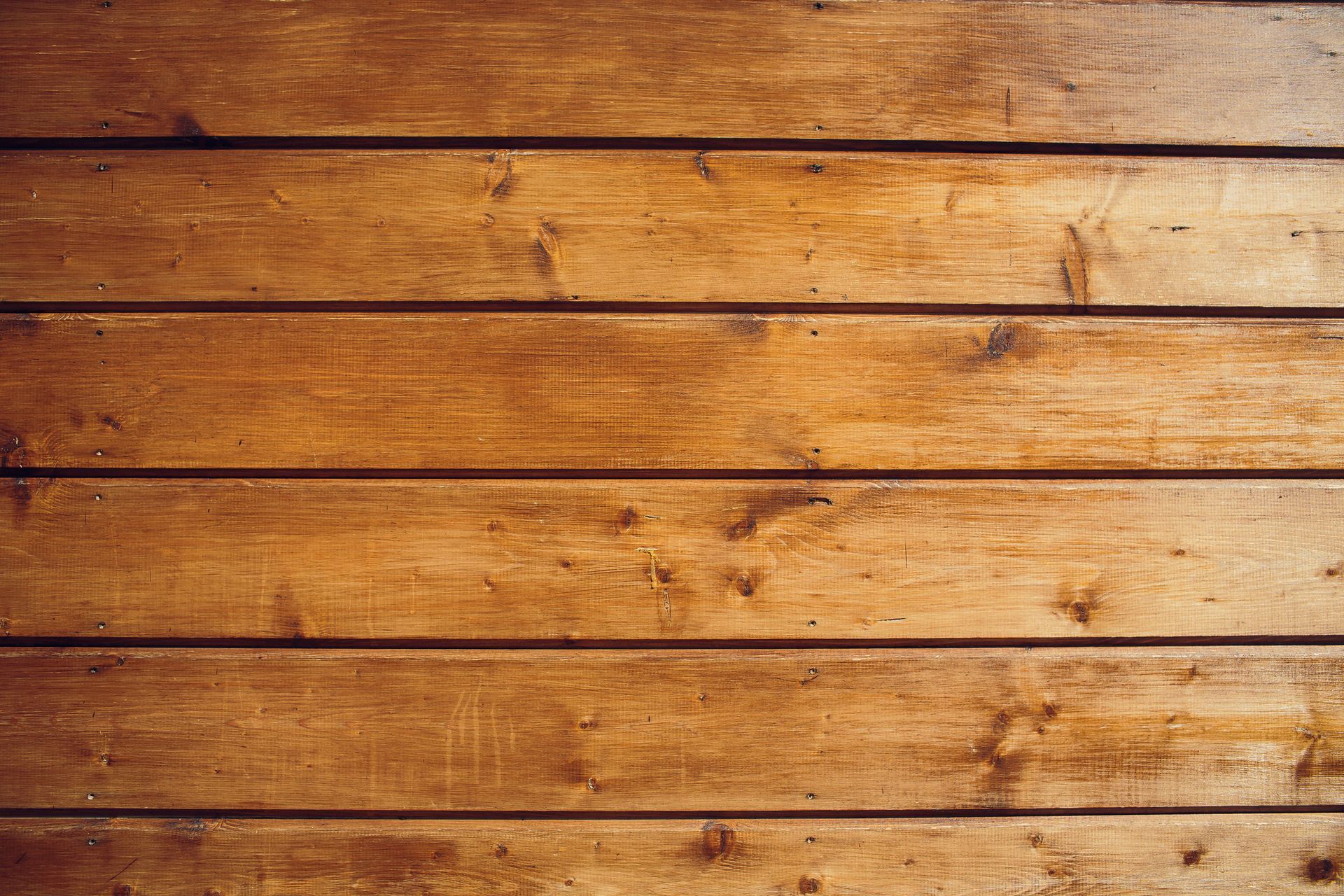 Brown wooden planks, horizontal orientation, showing wood grain and some knots.