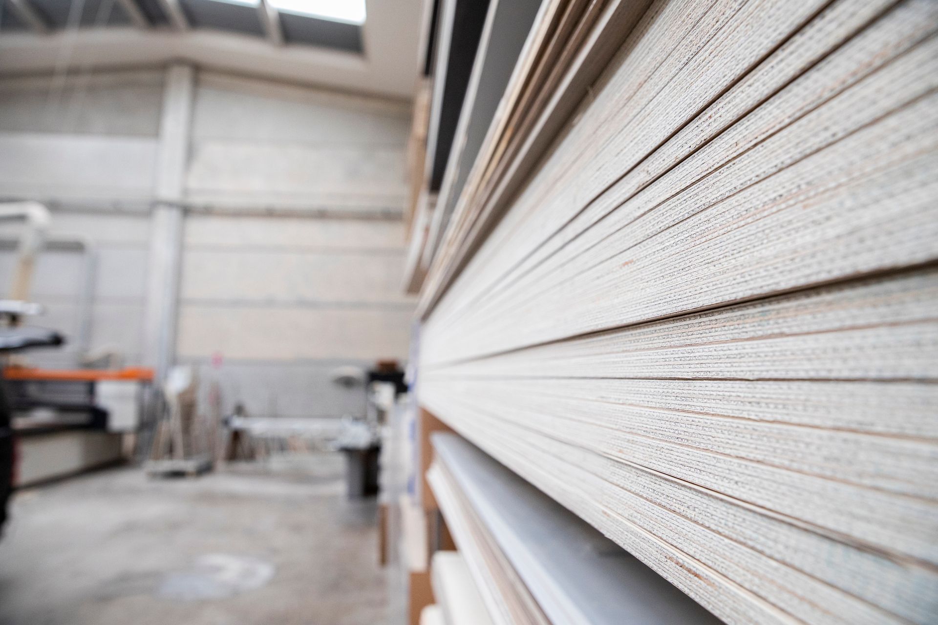Stack of light-colored wood panels in a workshop.