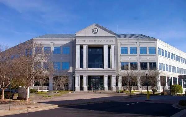 Exterior of the United States District Court, a modern building with columns and many windows under a blue sky.