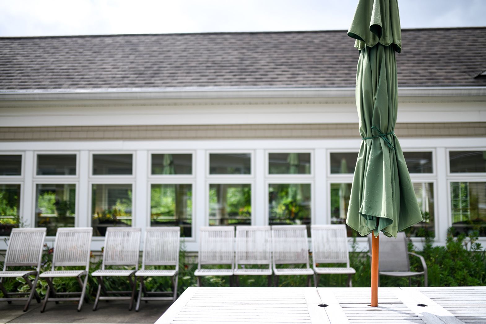Outdoor patio with umbrella and seating area at Bellamy Assisted Living