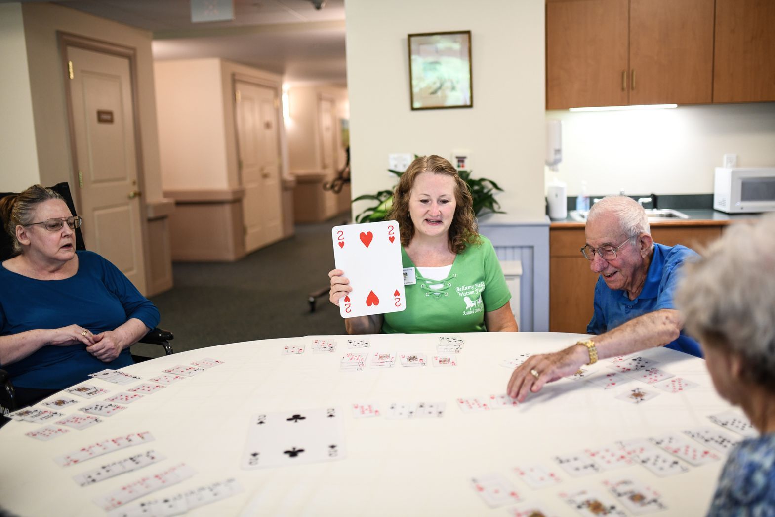 Caregiver engaging with residents during a group game session at Bellamy Assisted Living