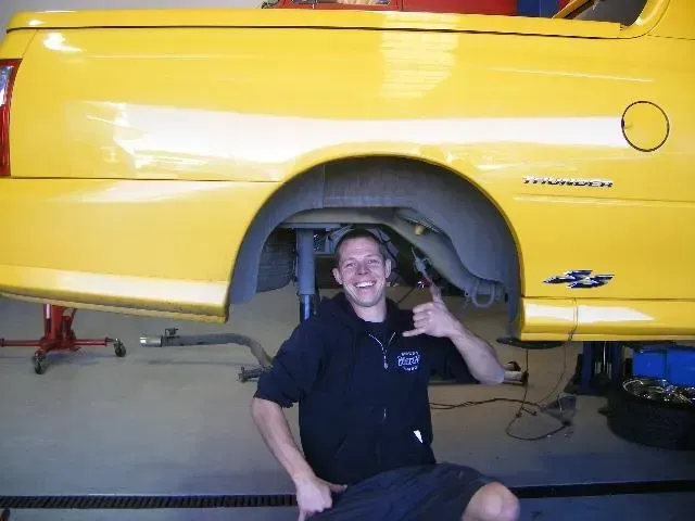 A White Truck With The Hood Up Is On A Lift In A Garage — Browns Autobahn In Nambour, QLD