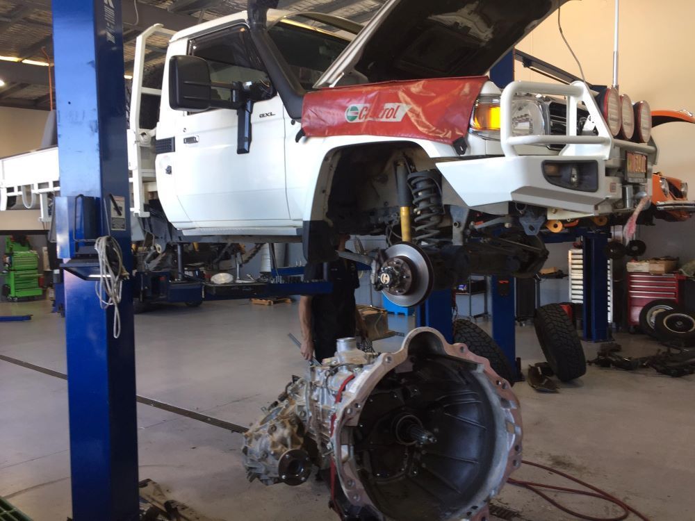 A White Truck Is On A Lift In A Garage With The Hood Open — Browns Autobahn In Nambour, QLD