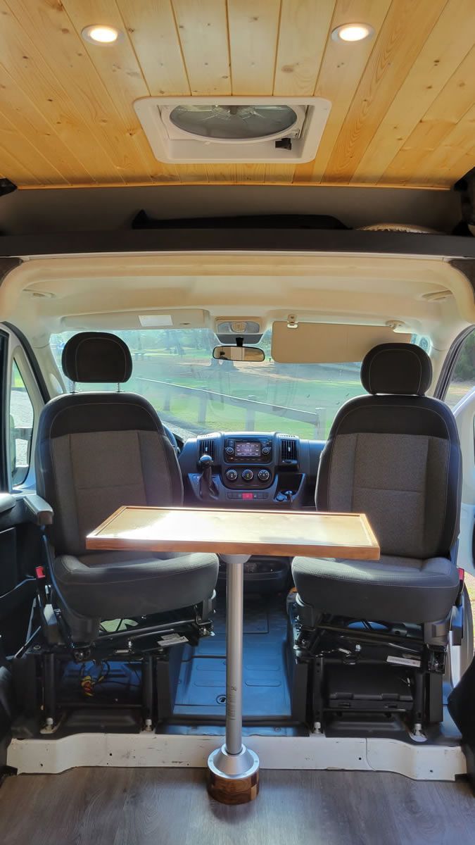The inside of a van with a table and chairs.