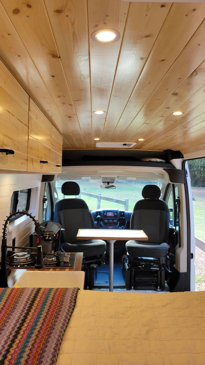 The inside of a van with a table and chairs.