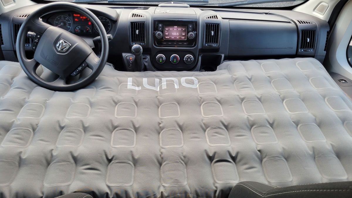 A mattress is sitting in the middle of a car.