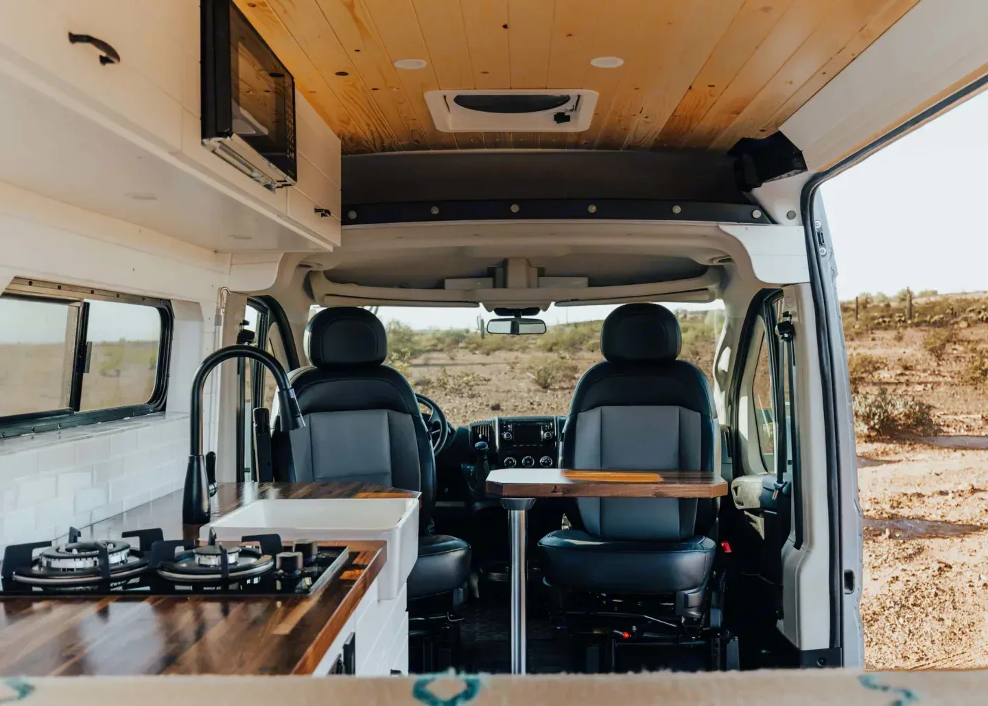 The inside of a van with a table and chairs.