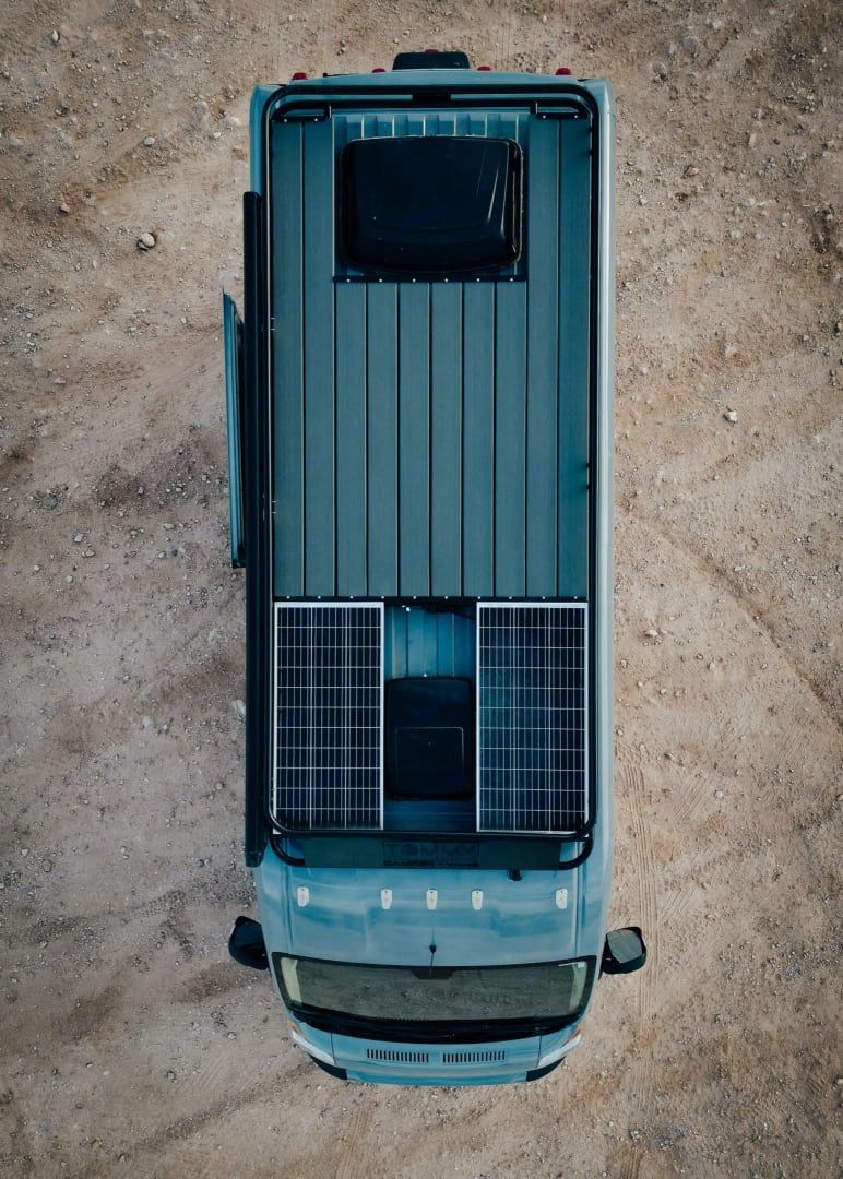 An aerial view of a van with solar panels on the roof.