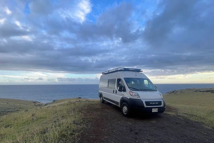 A white van is parked on the side of the road.