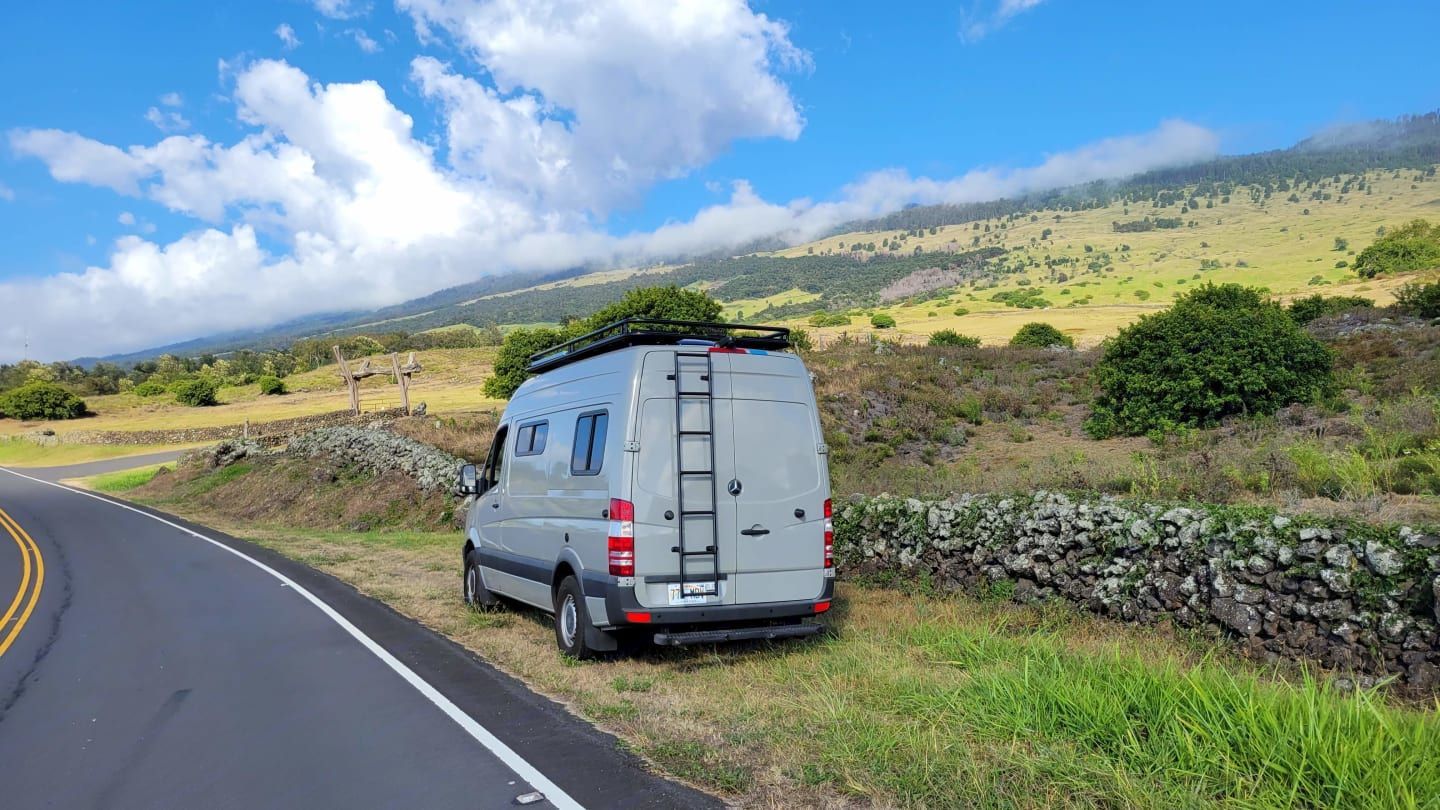 A white van is parked on the side of a road.