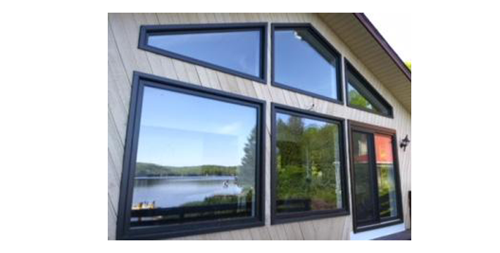 Une maison avec beaucoup de fenêtres et une vue sur un lac.