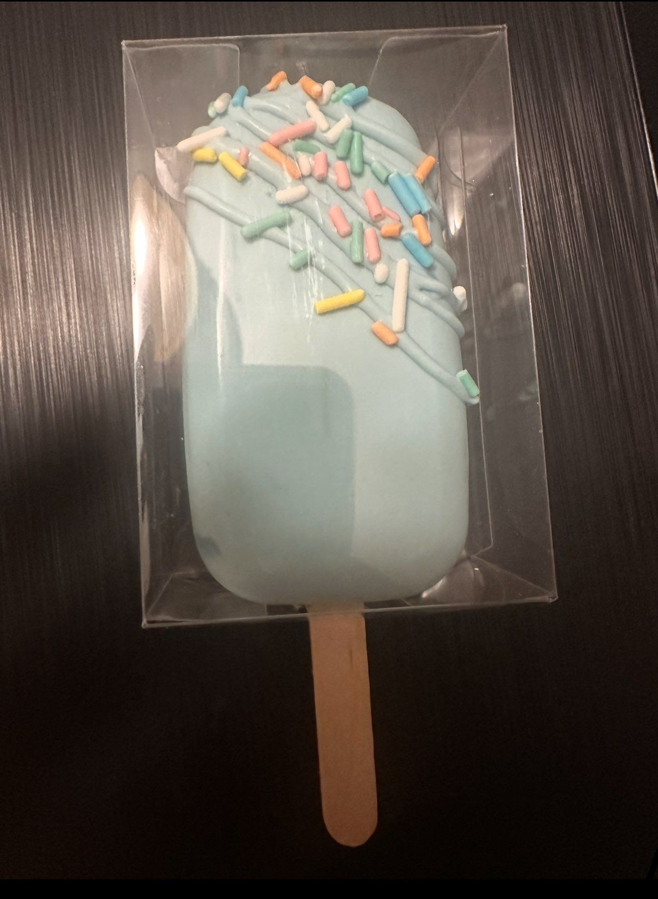 A blue ice cream popsicle with sprinkles on it