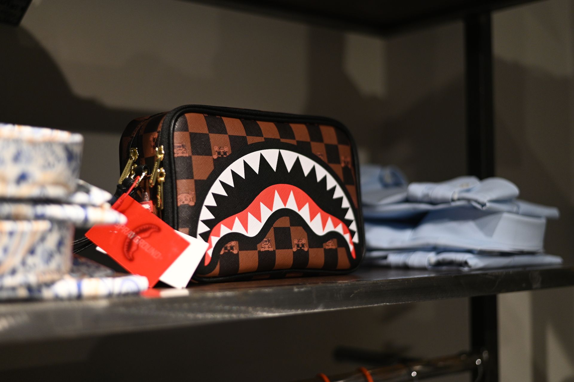 C'è una borsa con sopra uno squalo sullo scaffale di un negozio.