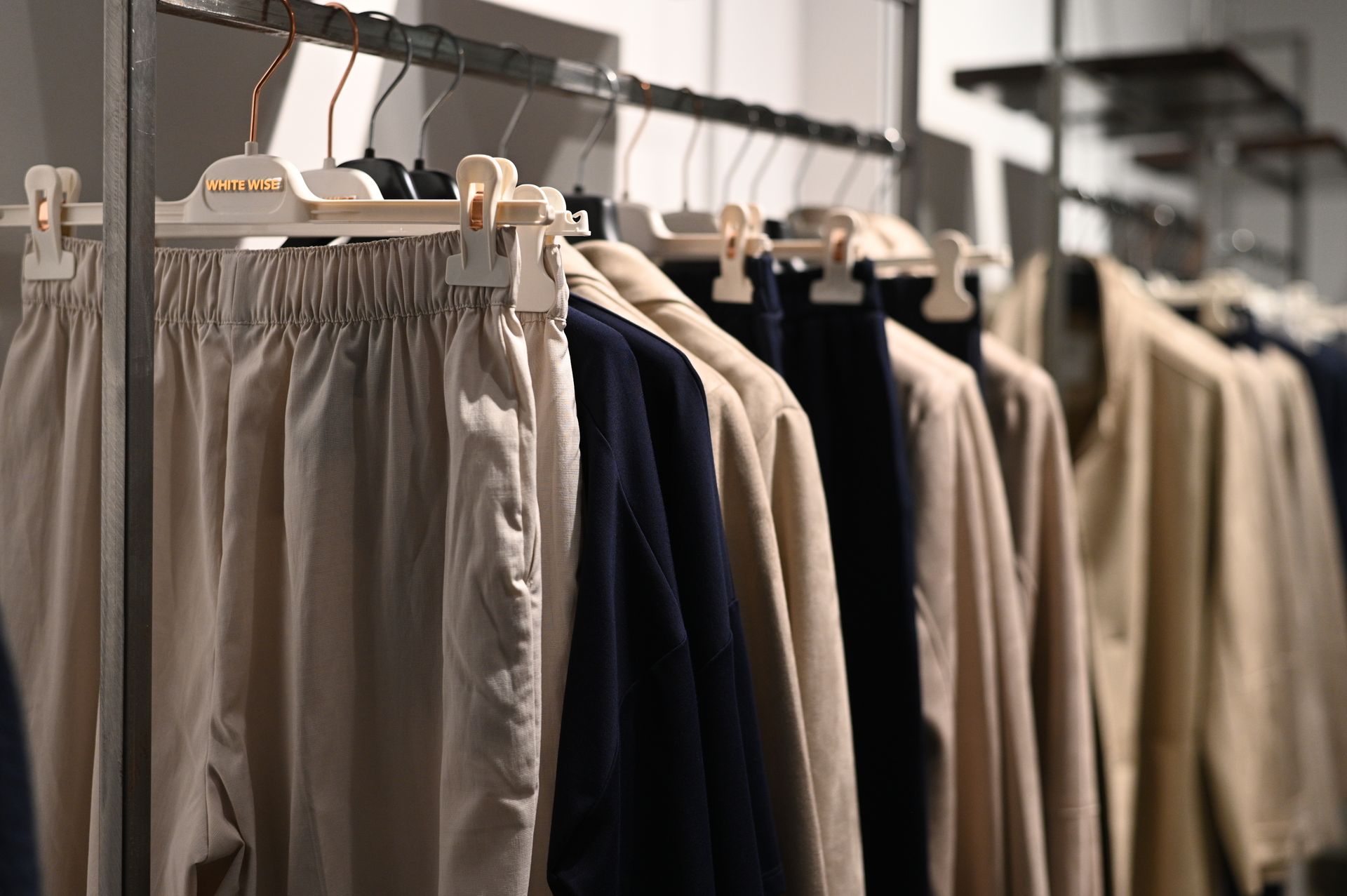 Una fila di vestiti appesi su uno scaffale in un negozio.