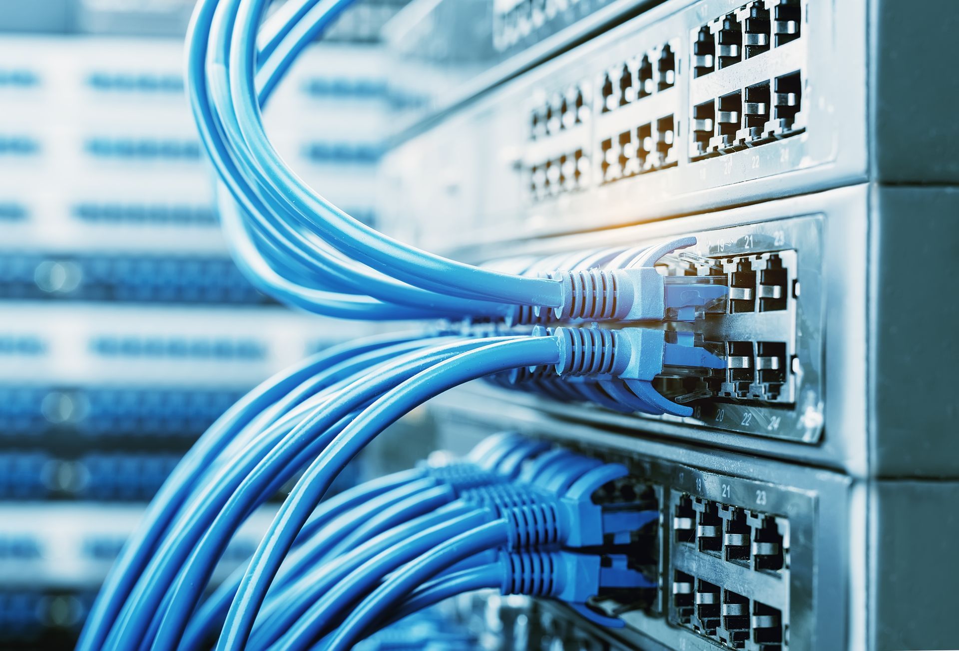 Blue Ethernet Cables Plugged Into Network Switches in a Server Room — INtelephony In Albury, NSW