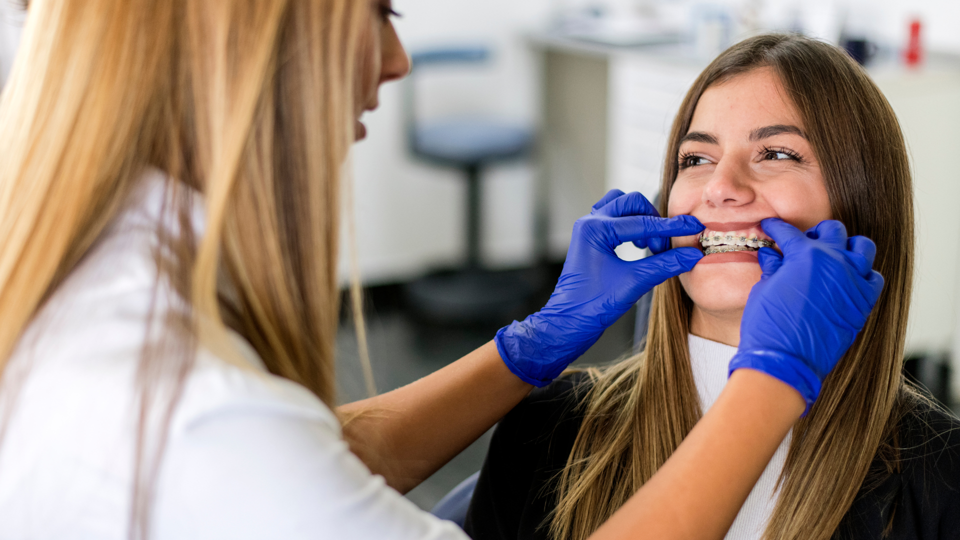 A woman is getting her teeth examined by a dentist.