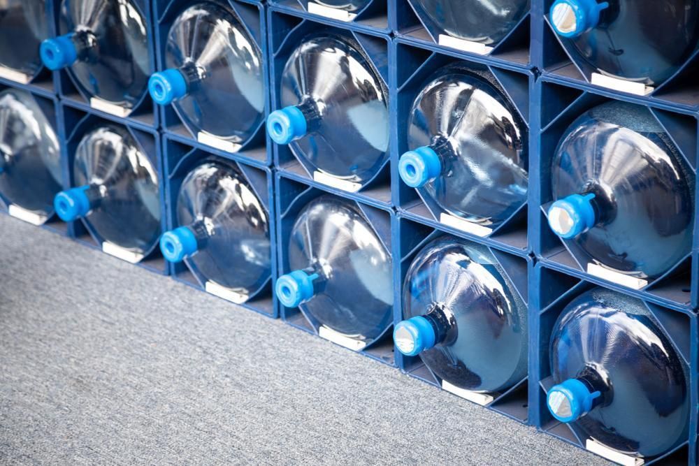 Close-up of a Stacked Grid of Large, Clear Plastic Water Jugs With Bright Blue Caps — Cool Blue Ice & Water in Forbes, NSW