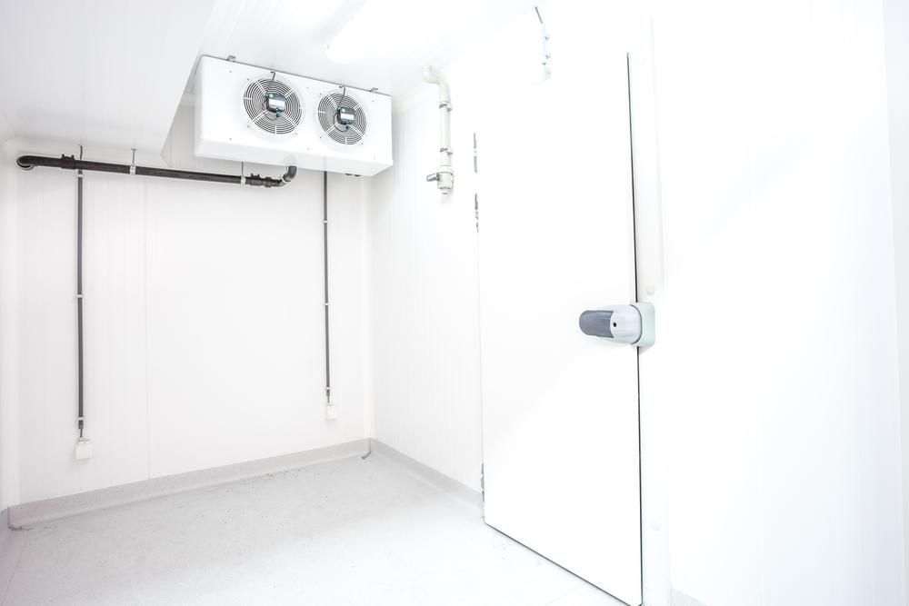 A Clean, White Walk-in Commercial Refrigerator With a Ceiling-mounted Cooling Unit — Cool Blue Ice & Water in Parkes, NSW