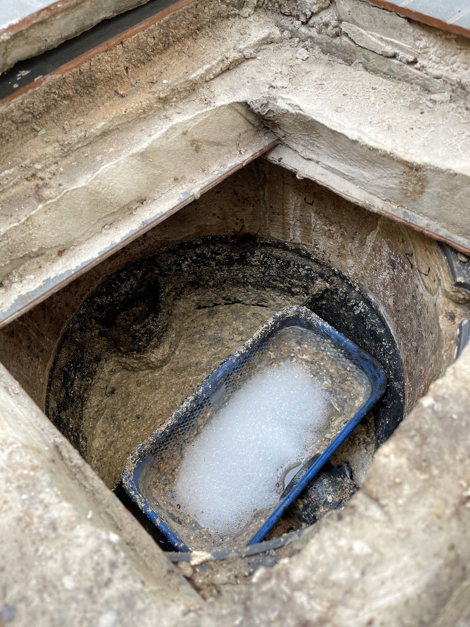 A blue tray is sitting in the middle of a hole in the ground.