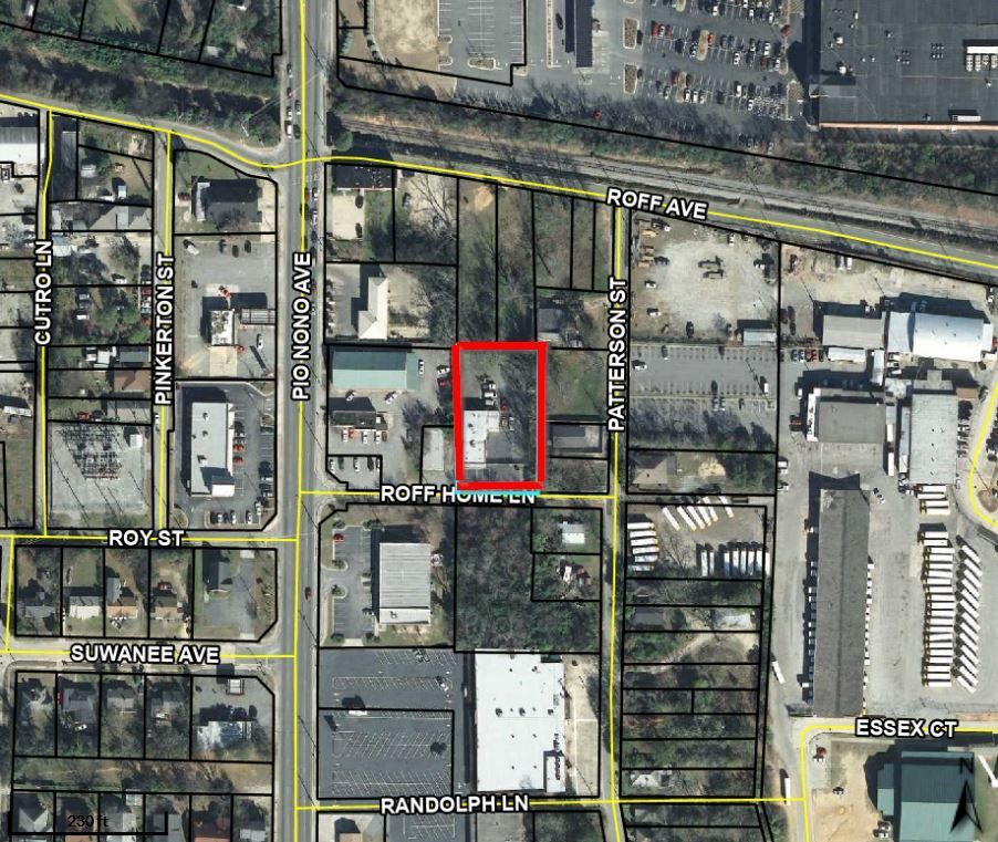 A small brick building with a parking lot in front of it.