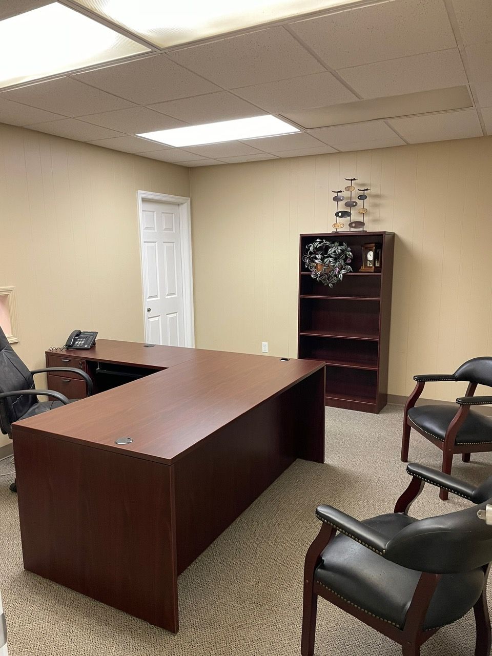 A room with a desk and chairs in it