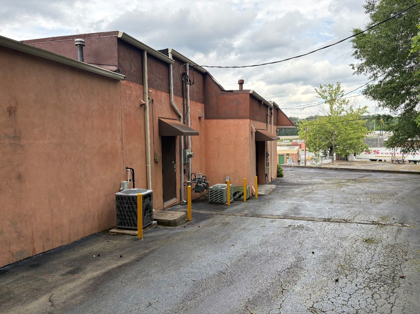 A row of buildings are lined up next to each other in a parking lot.
