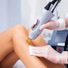 A woman is getting a laser hair removal treatment on her leg.