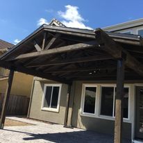 A house with a wooden covered porch in front of it.