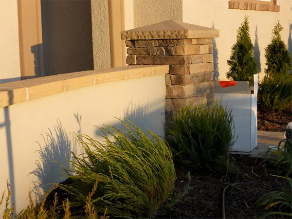 A white wall with a stone pillar in front of it