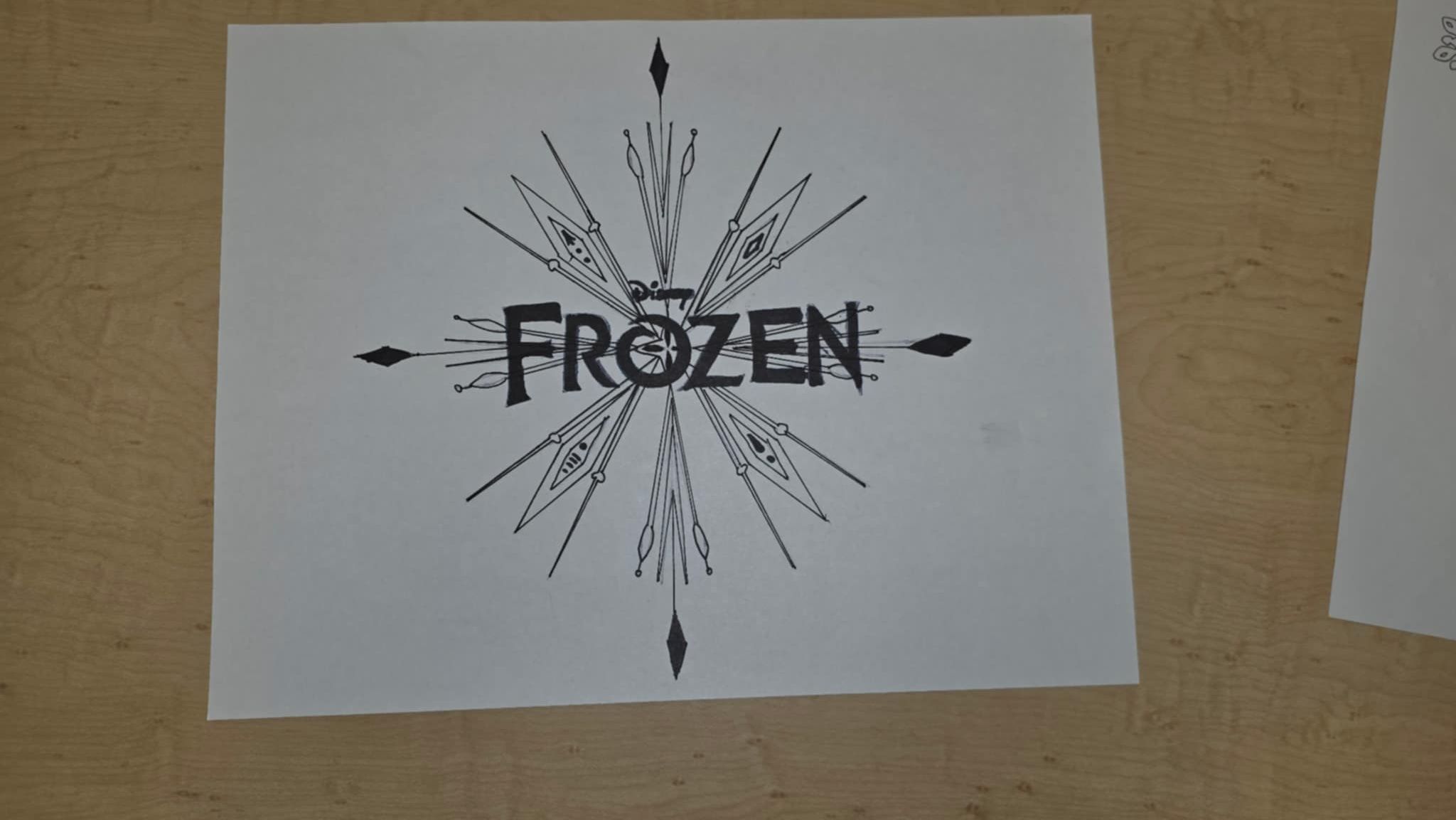 Frozen logo with snowflake design in black on white paper.