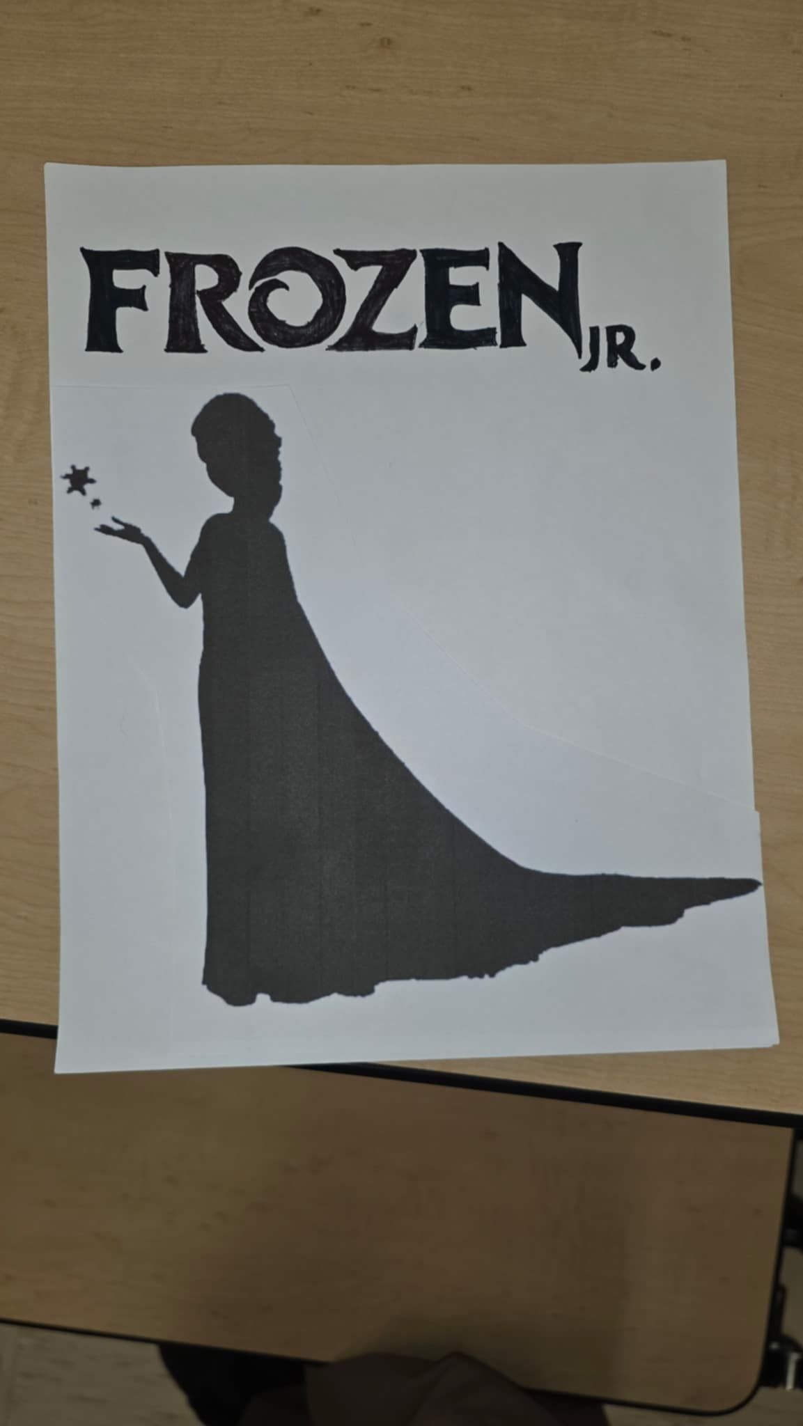 Frozen JR. poster with black text and silhouette of Elsa holding a star.