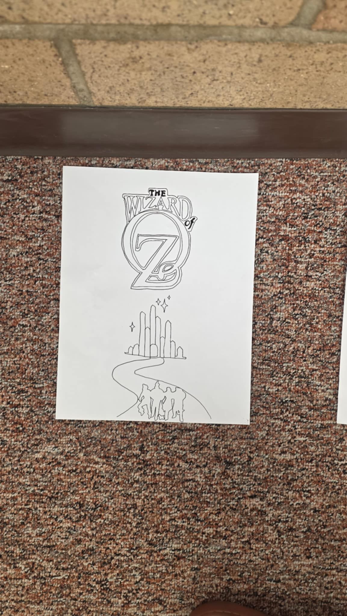 Black line drawing on white paper; abstract design of a figure.