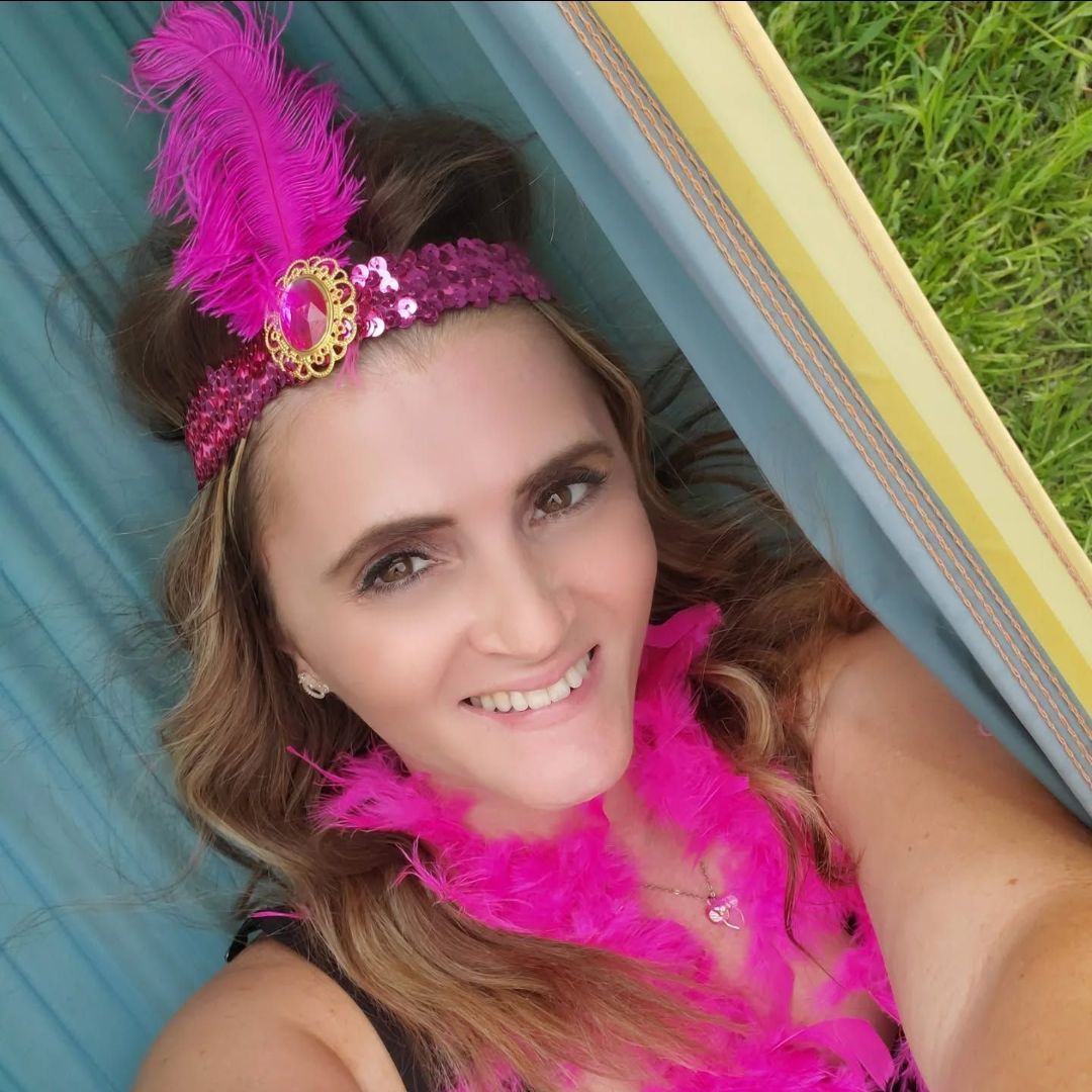 A woman wearing a pink feather headband and a pink boa