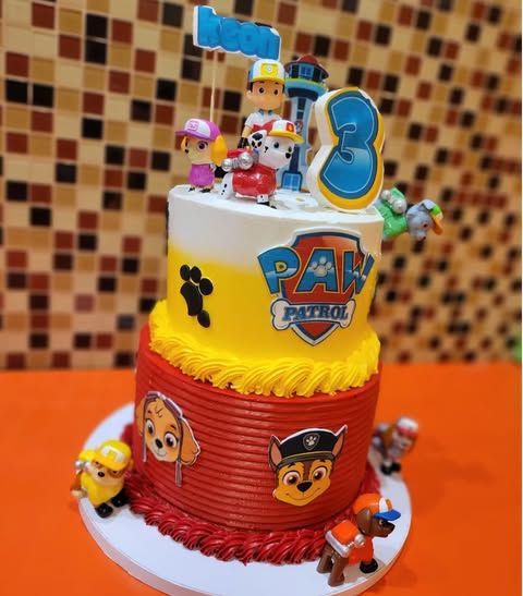 Paw Patrol birthday cake with characters and the number 3. Two tiers, red and yellow with toppers.