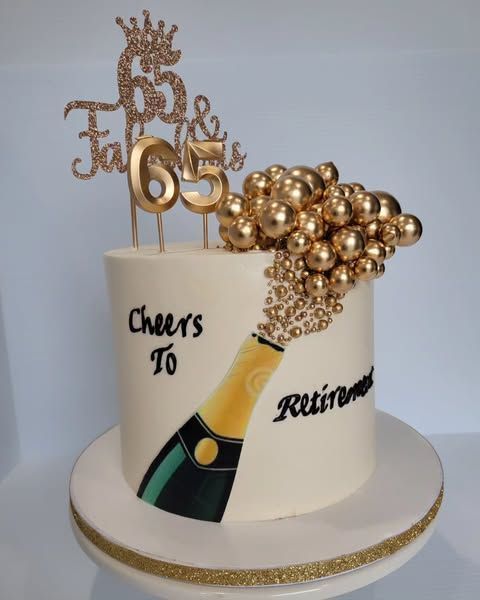 Cake celebrating retirement; white icing with gold accents, bubbly champagne, and a 