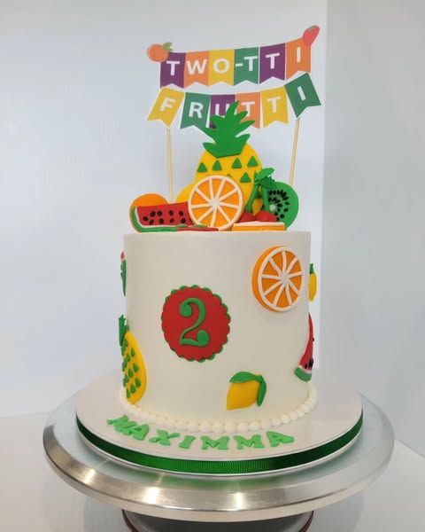 White cake decorated with colorful fruit and a 