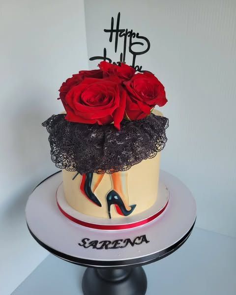 Cake decorated with red roses, lace, and stiletto heels. 