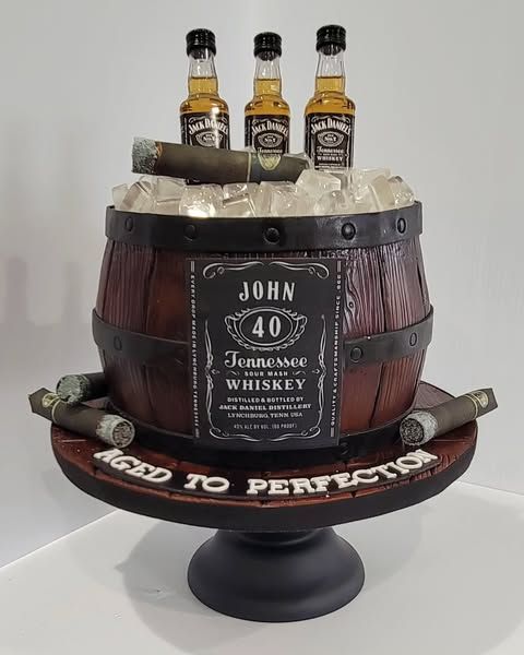 Whiskey barrel cake with cigars and miniature Jack Daniel's bottles, celebrating a 40th birthday.