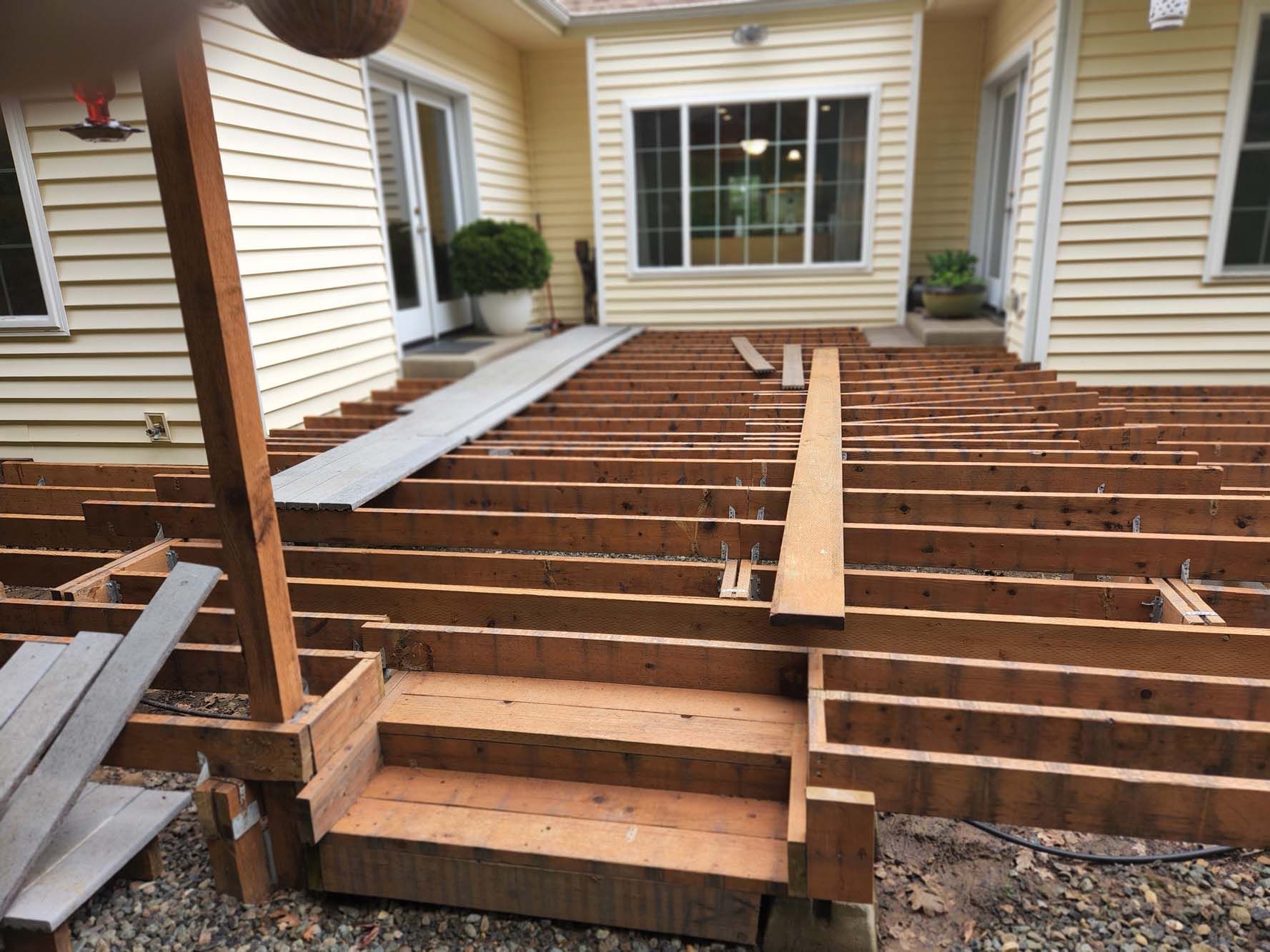 A wooden deck is being built in front of a house.
