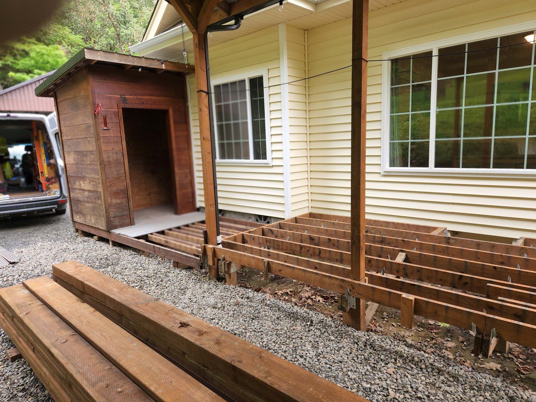 A wooden deck is being built in front of a house.