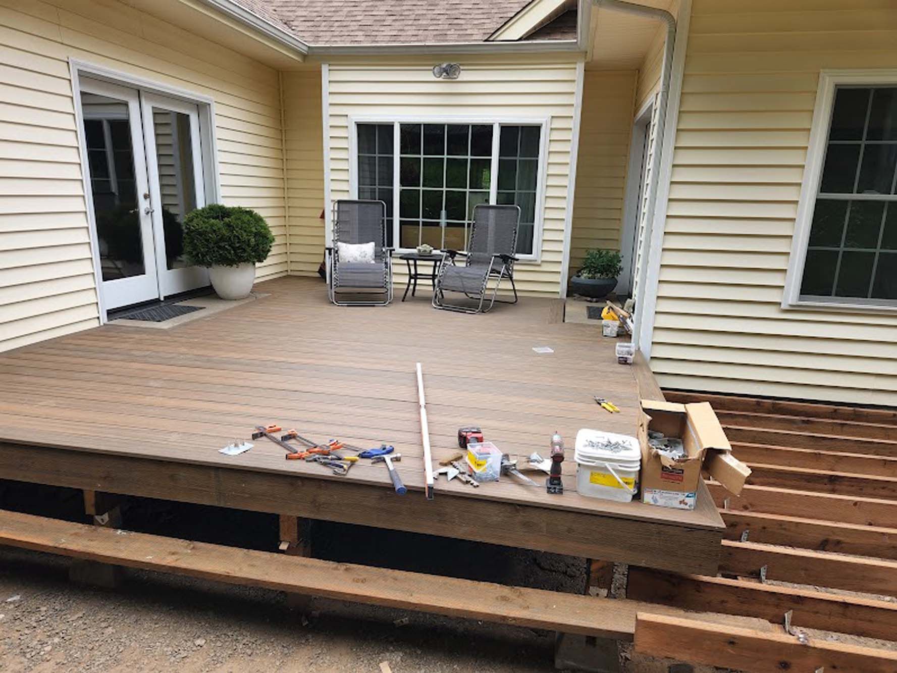A wooden deck is being built in front of a house.