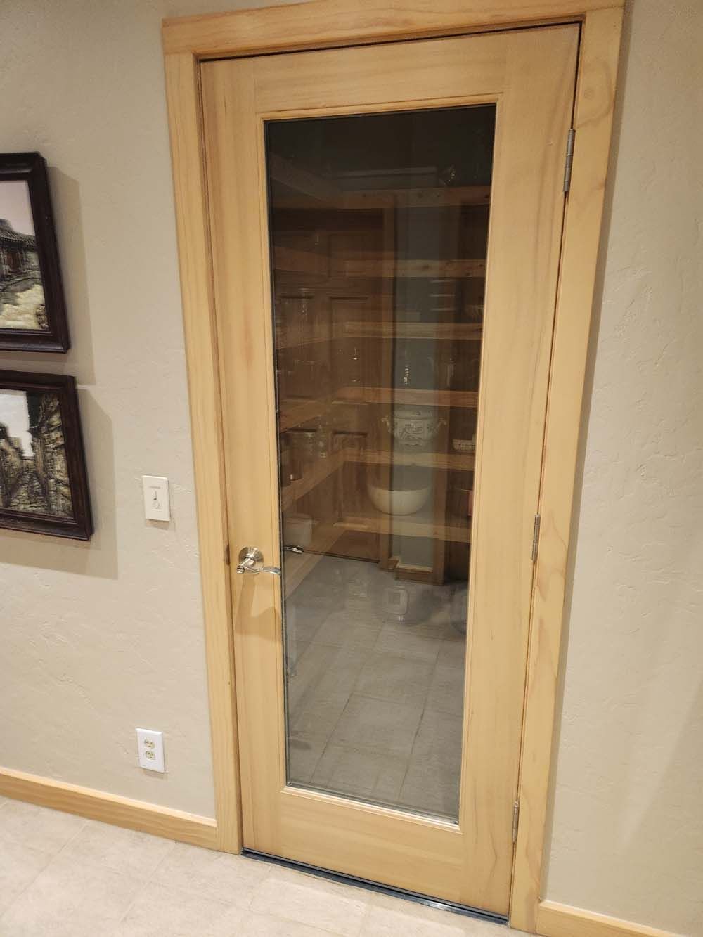 A wooden door with a glass window in a room.